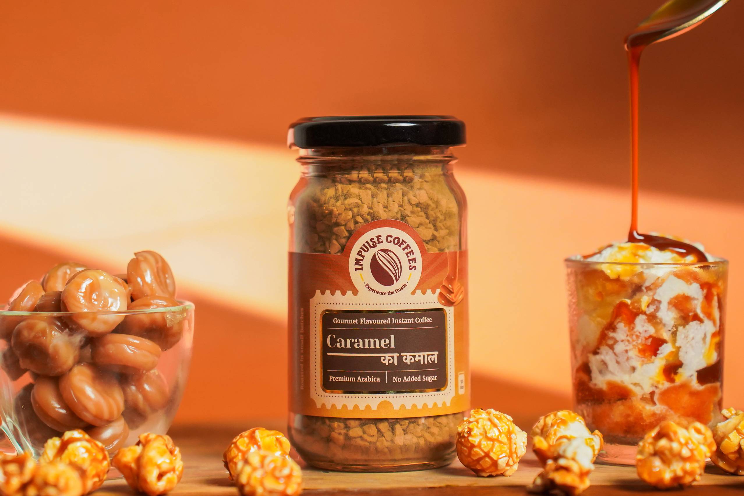 A jar of Caramel ka Kamal Instant Coffee Powder with caramel candies around it, suggesting a sweet coffee flavor.