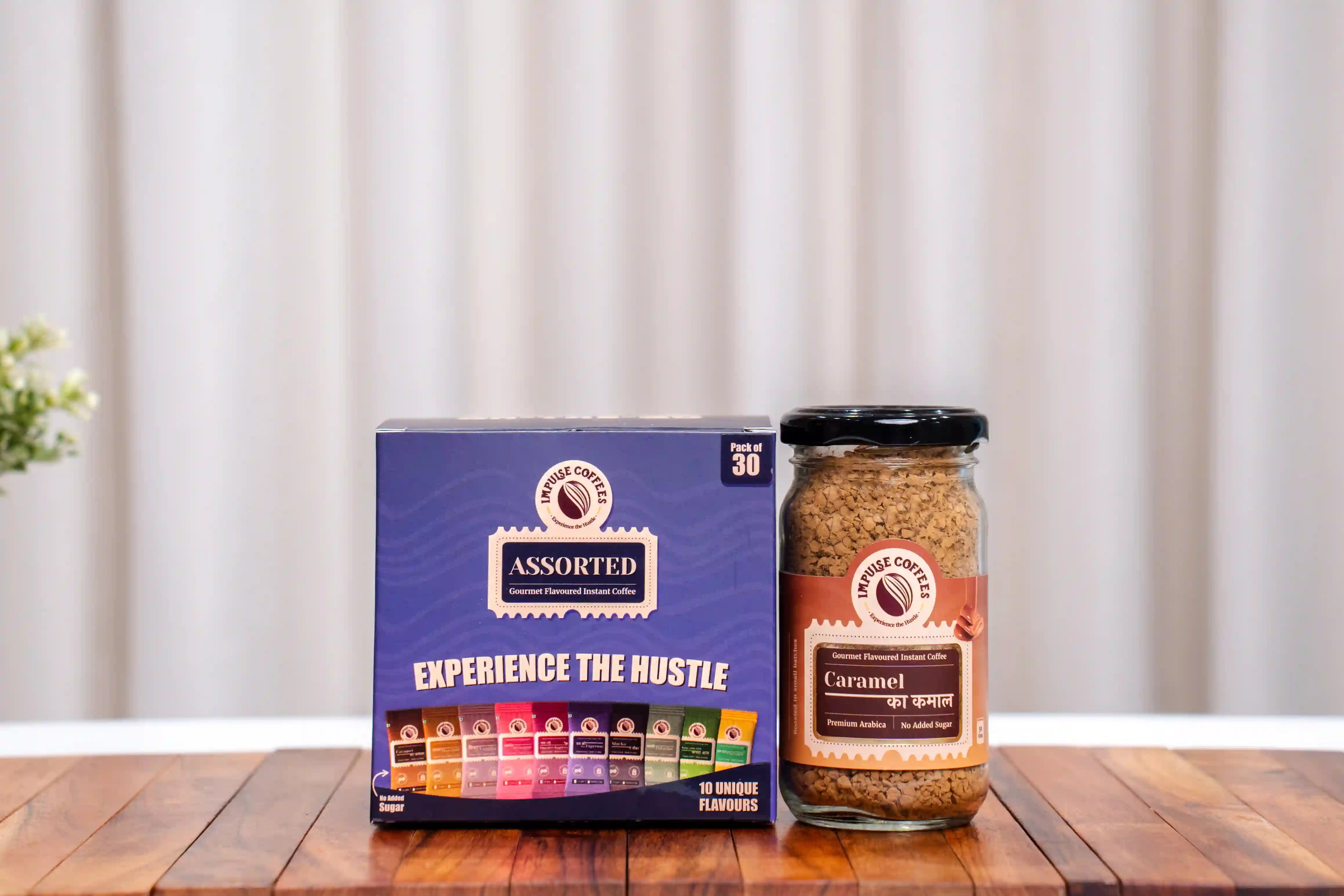 Assorted pack of 30 instant coffee sachets with 50gms Caramel Ka Kamal Coffee on a wooden surface with a neutral background