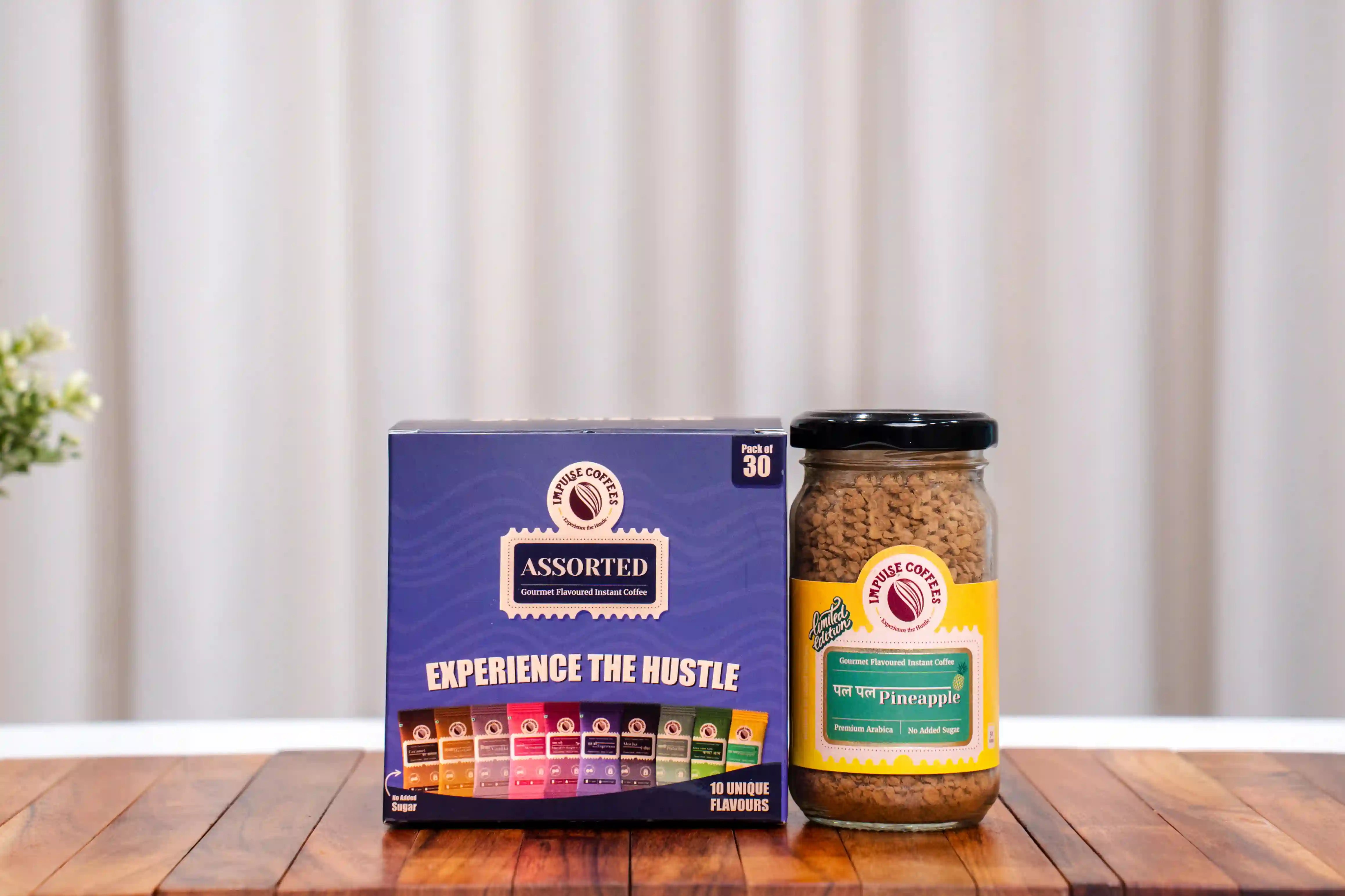 Assorted Coffee Box and Pal Pal Pineapple Coffee 50gms box and jar on a wooden surface with a white curtain background